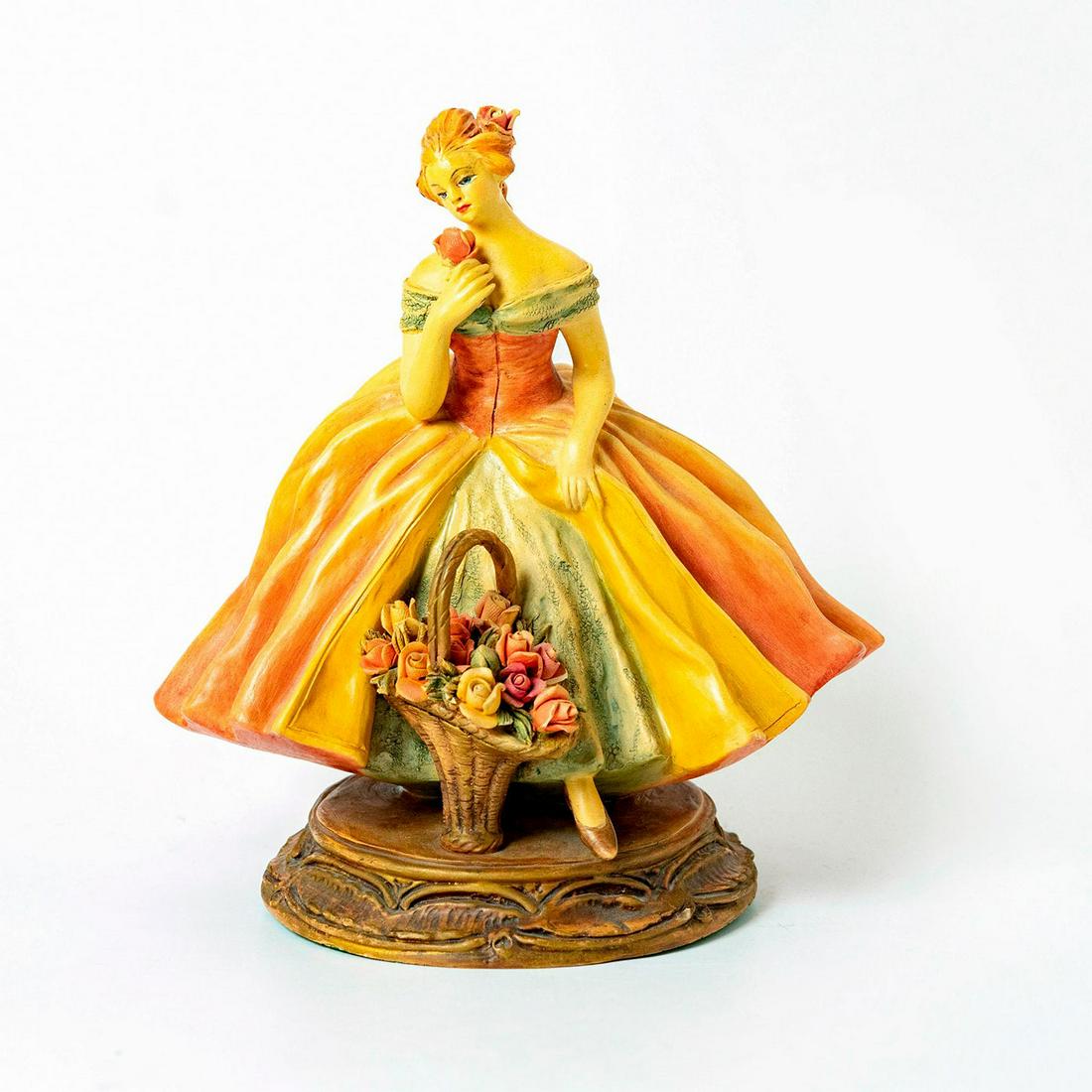 Cacciapuoti Porcelain Figurine: Elegant lady in orange and light green colors on brass base with floral basket holding a rose. Impressed signature, made in Italy and the number 953. Artist: Guido Cacciapuoti Issued: 1900-1940 Dimens