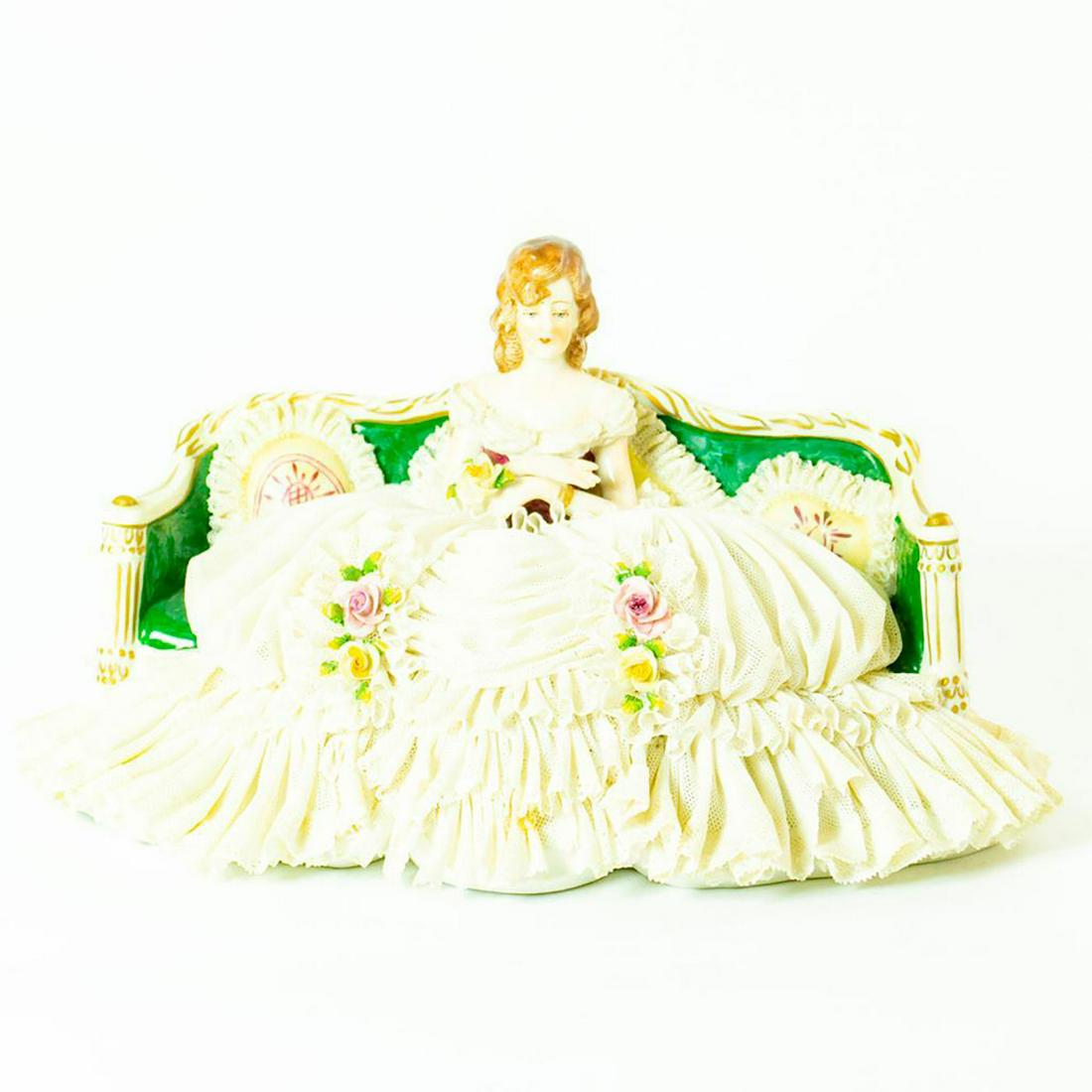 Franz Witter Figurine, Woman Seated On Couch: Extensive white porcelain lace; gilt accents; applied flowers. Woman seated with flower in hand. Franz Witter backstamp. Chipped lace on dress and cushions. Issued: 20th c. Dimensions: 6.5"H Manufactu