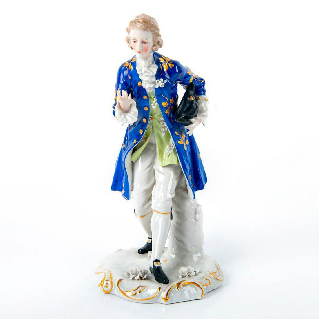 Franz Witter Style Figurine, Victorian Man: Glazed German porcelain figure. Hand painted; blue, green and white coloration; gilt highlights. Gentleman with hat in hand. Painted details; applied floral motifs; gilt highlights. Franz Witter mark
