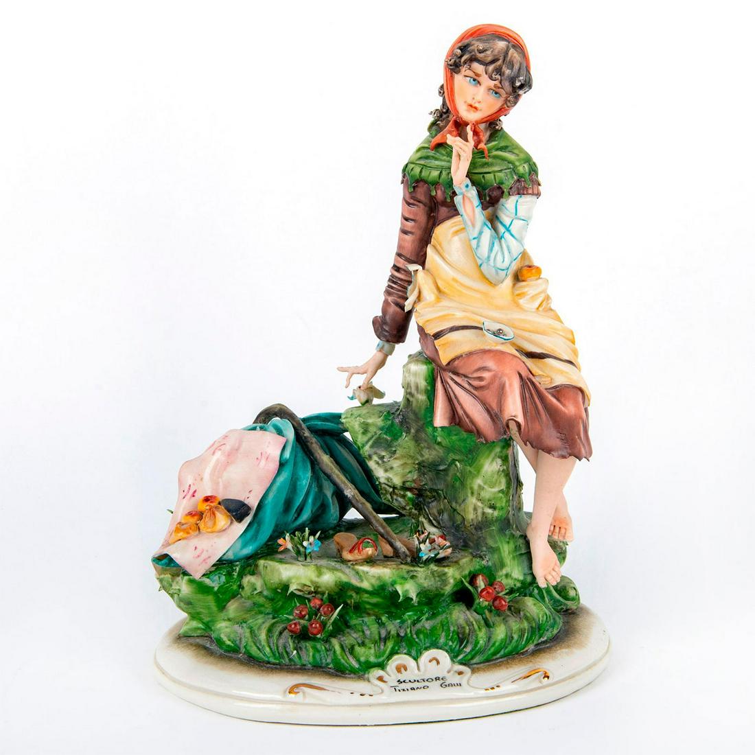 Taziano Galli Porcelain Figurine, Peasant Girl: Girl with headscarf, walking stick and traveling blanket is sitting on a rock with a little bird and money dish on her lap. Matte finish with sharp and pointy edges. Signed by sculptor. Capodimonte ba