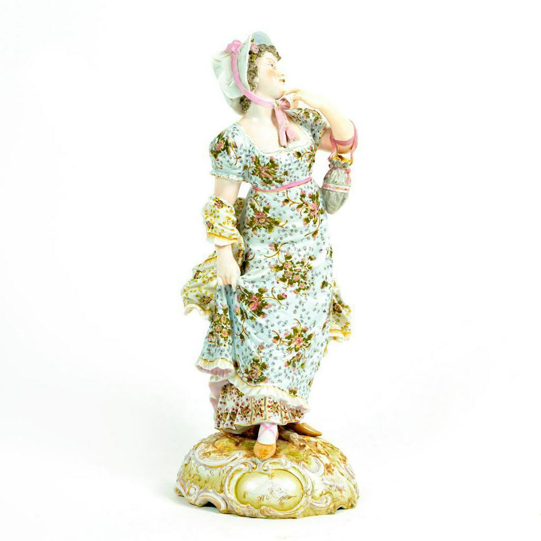 Volkstedt Porcelain Figurine, Lady Floral Dress: Curly haired lady in pink and blue floral dress with flowing scarf. White bonnet with pink bow. Volkstedt backstamp. The crossed pitchforks were the factory mark from 1760. Broken bow on bonnet. Issue