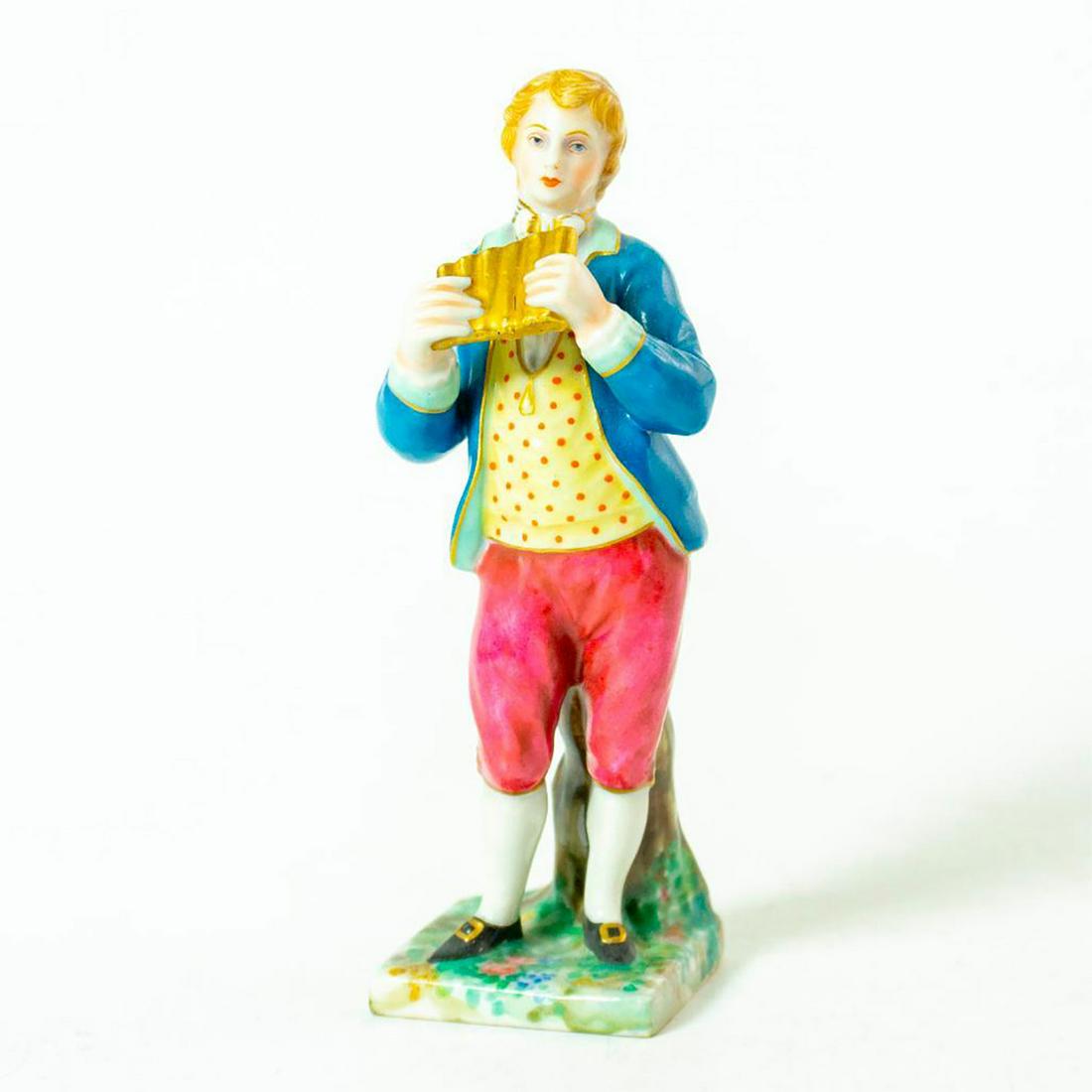 Vintage Porcelain Figurine Small, Pan Flute: Man in blue blazer with yellow dotted shirt and red knee length pants holding a golden pan flute. Capodimonte backstamp. Issued: 20th c. Dimensions: 4"H Manufacturer: Capodimonte Country of Origin: It