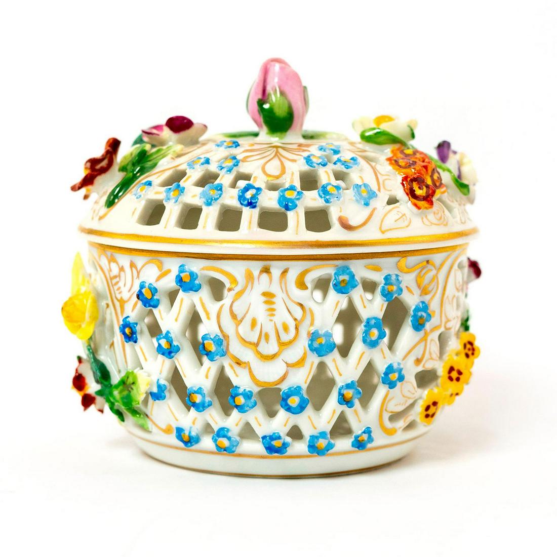 Ludwigsburg Porcelain Lidded Bowl: Glazed porcelain; reticulated bowl and lid with applied flowers; gilt accents. Ludwigsburg backstamp. Chips to petals. Issued: 19th c. Dimensions: 3.5"H Country of Origin: Germany
