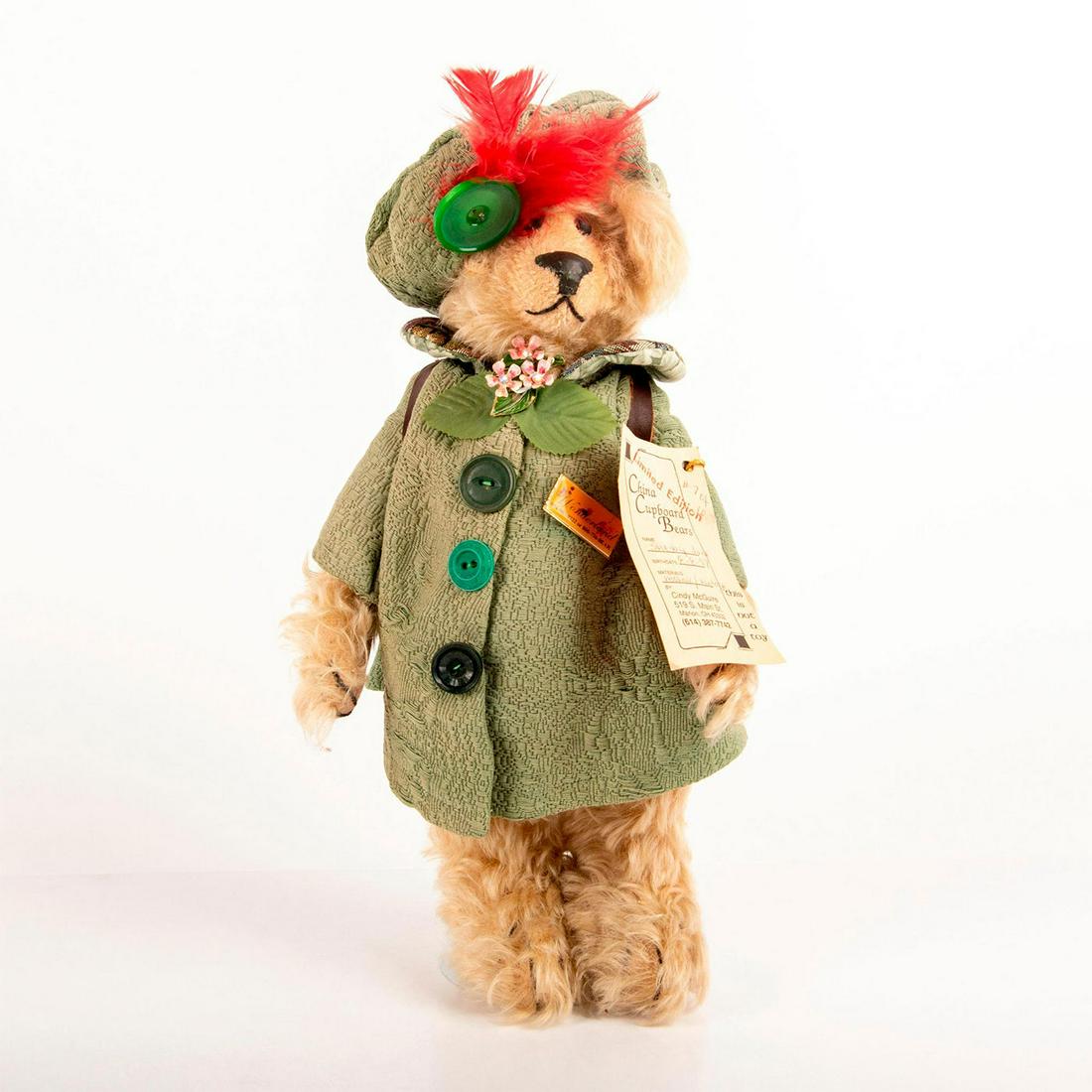China Cupboard Bears, Shelby June: Blonde bear wearing green coat and green hat with red feather. With stand and manufacture tag on arm. Issued: 1997 Dimensions: 13"H Manufacturer: China Cupboard Bears Country of Origin: USA