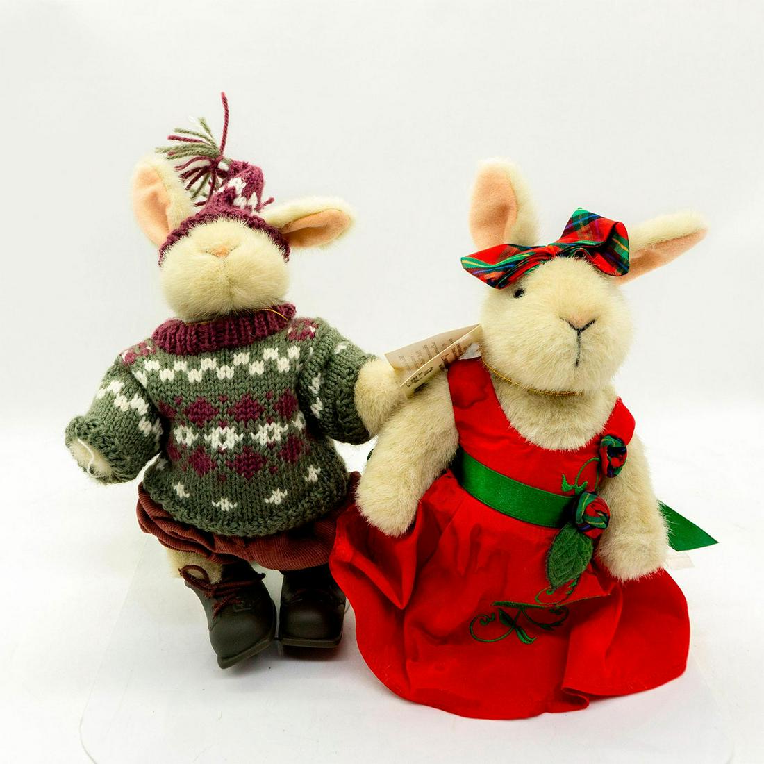 2 North American Plush Rabbits, Winter And Gala: Knitted green and purple sweater and matching cap. Elegant red dress with green floral stitching. Hoppy VanderHare collection. Jointed limbs. Original tags attached. One comes with stand. Age related 
