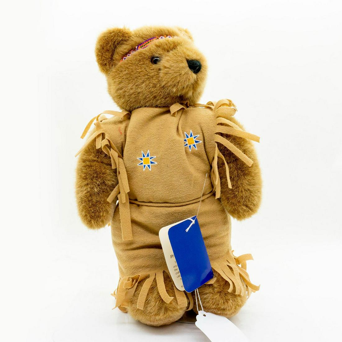 Oz Teddy Bear, Lonestar Bear: Plush, glass eyes, wearing native American uniform, original tag attached and display stand included. Issued: 20th c. Dimensions: 13.5"H Manufacturer: Oz Country of Origin: United States