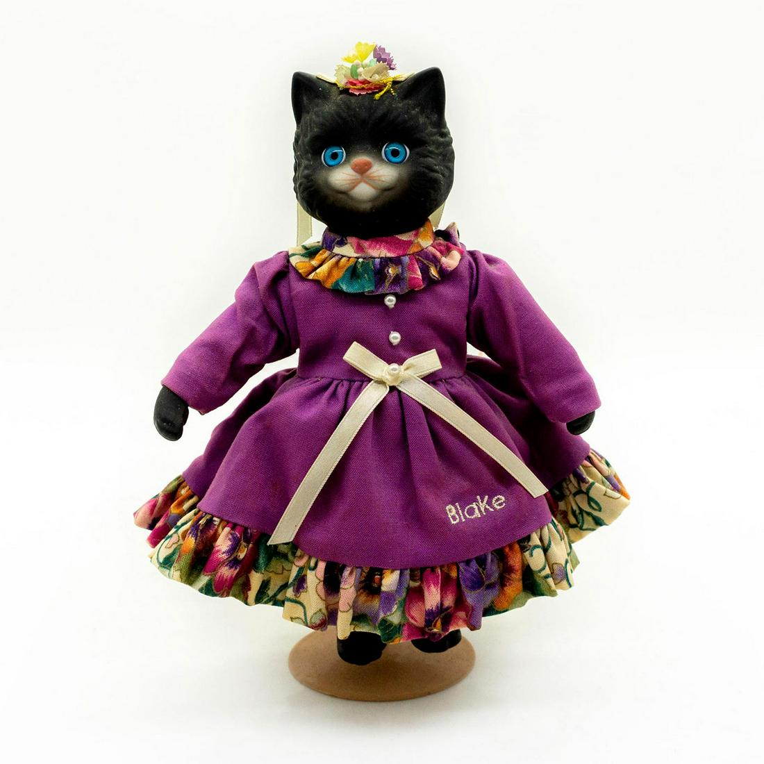Goebel, Dolly Dingle Porcelain Cat Doll, Bootsie Blake: Limited edition 656 of 1,000. Lovely cat is wearing a purple dress with pearl accents and a flower head dress. Comes with original tag and metal doll stand. #porcelaindoll #bisquedoll #cat Artist: Kar