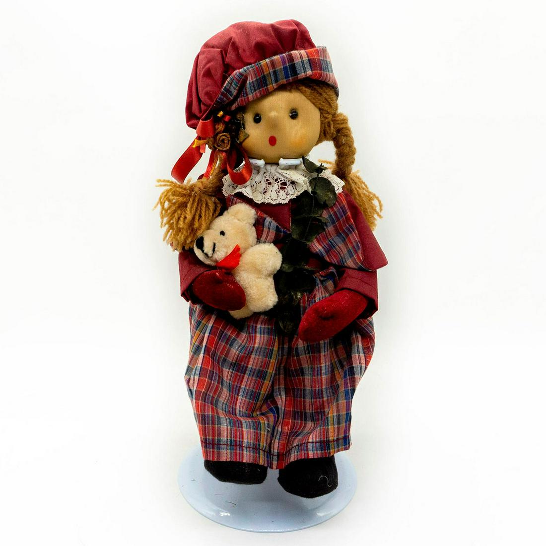 Holiday Doll, Girl Carol Singer: Lovely doll in burgundy plaid dress and hat with lace detail and underskirt. Pig tail braids are threads and she is decorated with dried twig and Christmas bow. Legs are jointed. Her face is a modeled