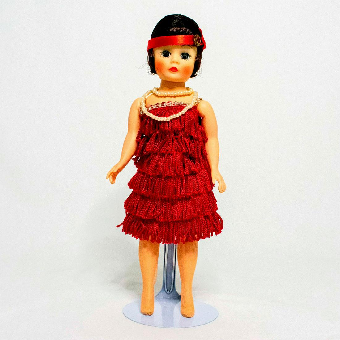 Madame Alexander Doll, Flapper: Doll has brown hair and blue eyes. Wears a red headband, 2 pearl necklaces, red flapper dress, and nude stockings. Shoes are missing. #madamealexander #doll #flapper Issued: 20th c. Dimensions: 9"H Ma