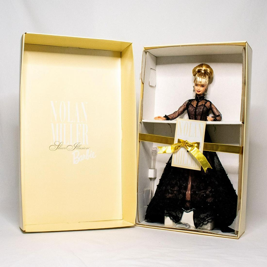 Mattel Barbie Doll, Nolan Miller Sheer Illusion: Barbie wears a delicate slip-style gown of sheer black tulle, highlighted with a lacy trim on her long skirt, designed by Nolan Miller couture. A high collared, full-length jacket of jet-black tulle d