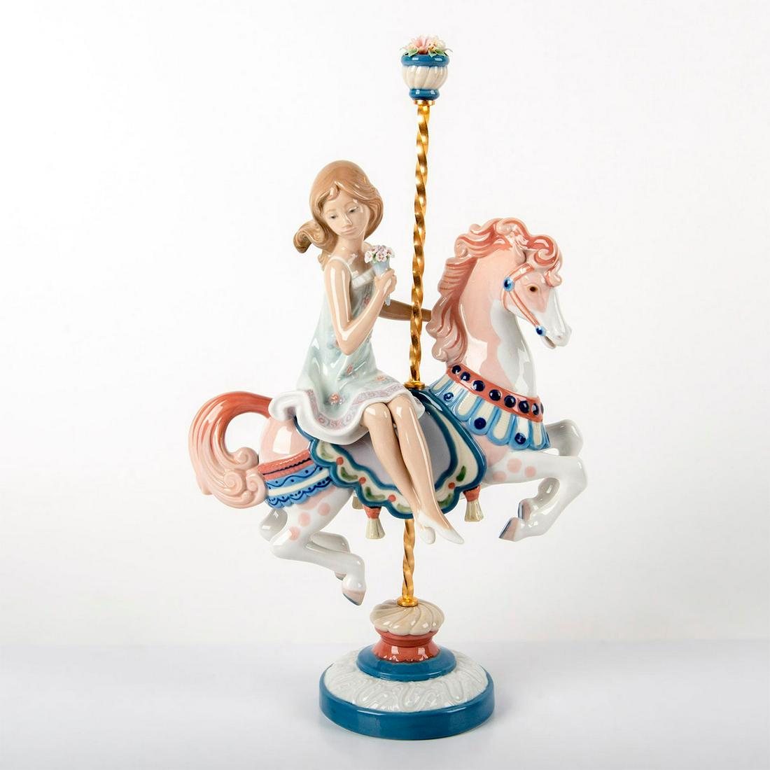Girl On Carousel Horse 1001469 - Lladro Porcelain: Glossy porcelain of a girl on a horse carousel. Comes with original box. Lladro backstamp. Chipped flower petal. Artist: Jose Puche Issued: 1985-2000 Dimensions: 15"H x 9"W Manufacturer: Lladro Countr