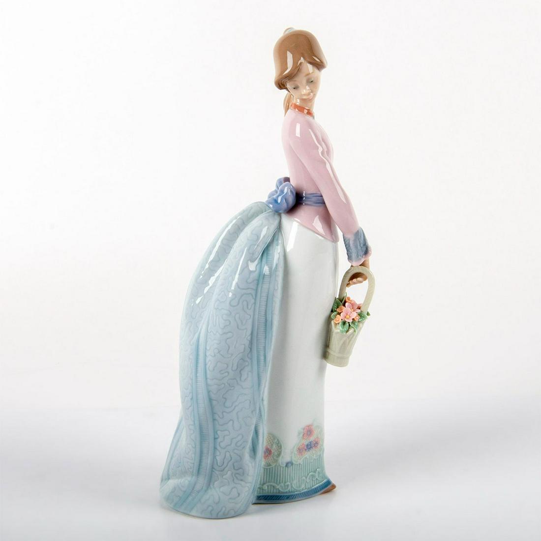 Basket of Love 1007622 - Lladro Porcelain Figurine: Glossy porcelain; modeled as a girl with a flower basket. Comes with original box. Lladro backstamp. Sticker residue on the skirt. Artist: Jose Puche Issued: 1994 Dimensions: 9.75"H x 4"W Manufacturer