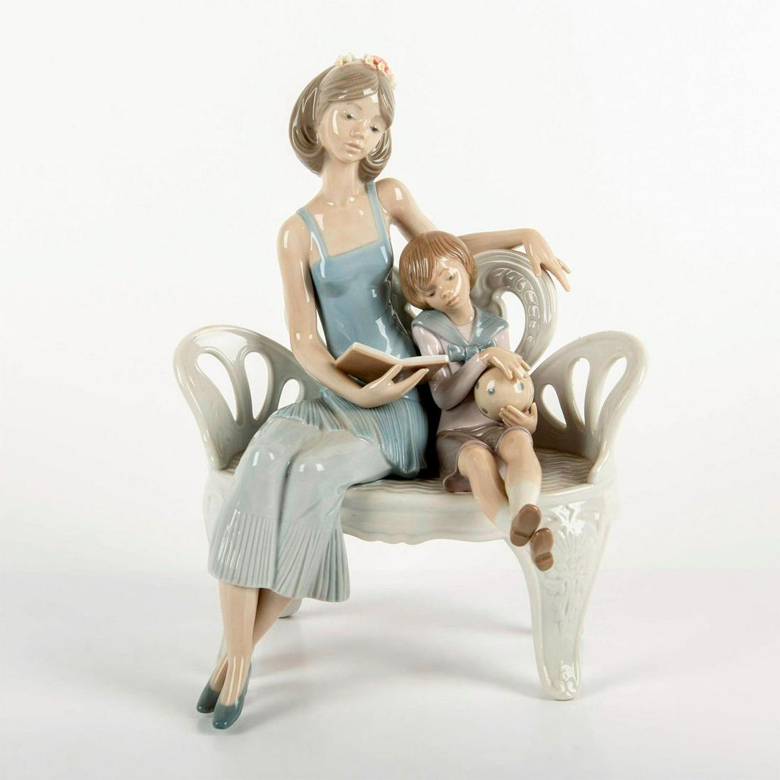 Once Upon a Time 1005721 - Lladro Porcelain Figurine: Glazed; Mother and son on bench reading book. Comes with original box. Chipped flower petals on mother's headband. Lladro backstamp. Artist: Francisco Catala Issued: 1990-1997 Dimensions: 10.25"H x 6.