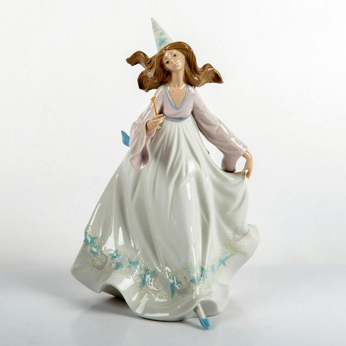 Fairy Godmother 1005791 - Lladro Porcelain Figurine: Glossy finish; Fairy godmother leaning forward, with long flowing hair. Lladro backstamp. Original box included. Artist: Jose Puche Issued: 1991 - 1994 Dimensions: 11"H Manufacturer: Lladro Country of