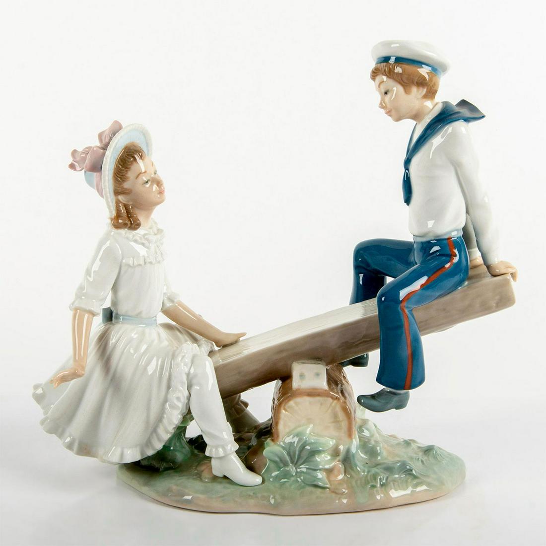 See-Saw 1001255 - Lladro Porcelain Figurine: Glazed; Boy and girl on see saw. With box. Lladro backstamp. Artist: Vincente Martinez Issued: 1974 Dimensions: 9.5"H Manufacturer: Lladro Country of Origin: Spain