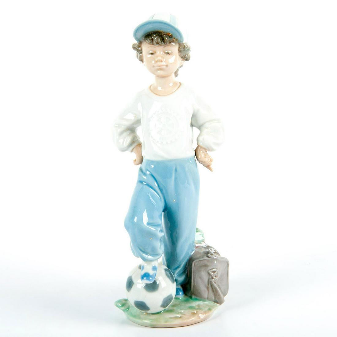Starting Forward 1007605 - Lladro Porcelain Figurine: Glossy finish; Boy with a soccer ball. Lladro and Rotary Club Special backstamp. Box included. Artist: Antonio Ramos Issued: 1989 - 2004 Dimensions: 8.75"H x 3.25"W Manufacturer: Lladro Country of Ori