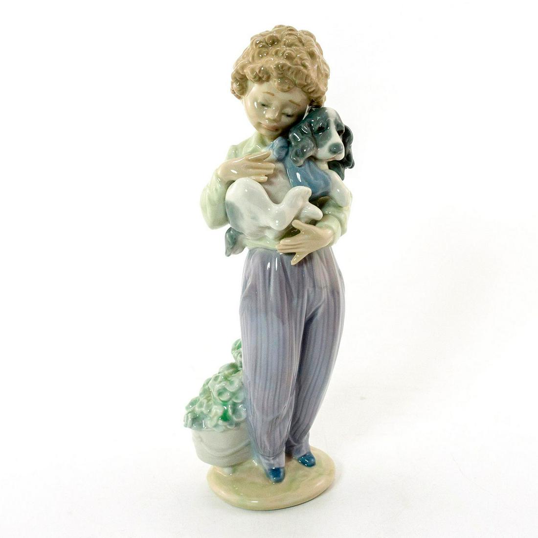 My Buddy 01007609 - Lladro Porcelain Figurine: Glossy porcelain figurine; A boy cradling his dog. No box. Lladro backstamp. Artist: Antonio Ramos Issued: 1989-1989 Dimensions: 8.75"H x 3.25"W Manufacturer: Lladro Country of Origin: Spain