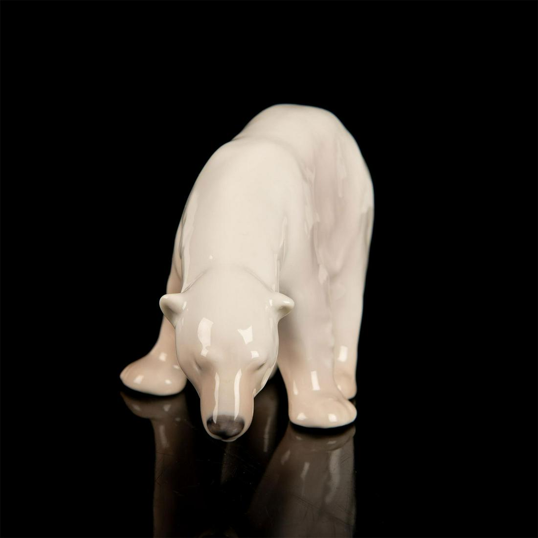 Royal Copenhagen Porcelain Figurine, Polar Bear Feeding: Figurine of an adult polar bear in standing position. White and light brown coloration Royal Copenhagen backstamp. Good condition. #polarbear Issued: 20th c. Dimensions: 5.5"W x 3.75"H Manufacturer: R