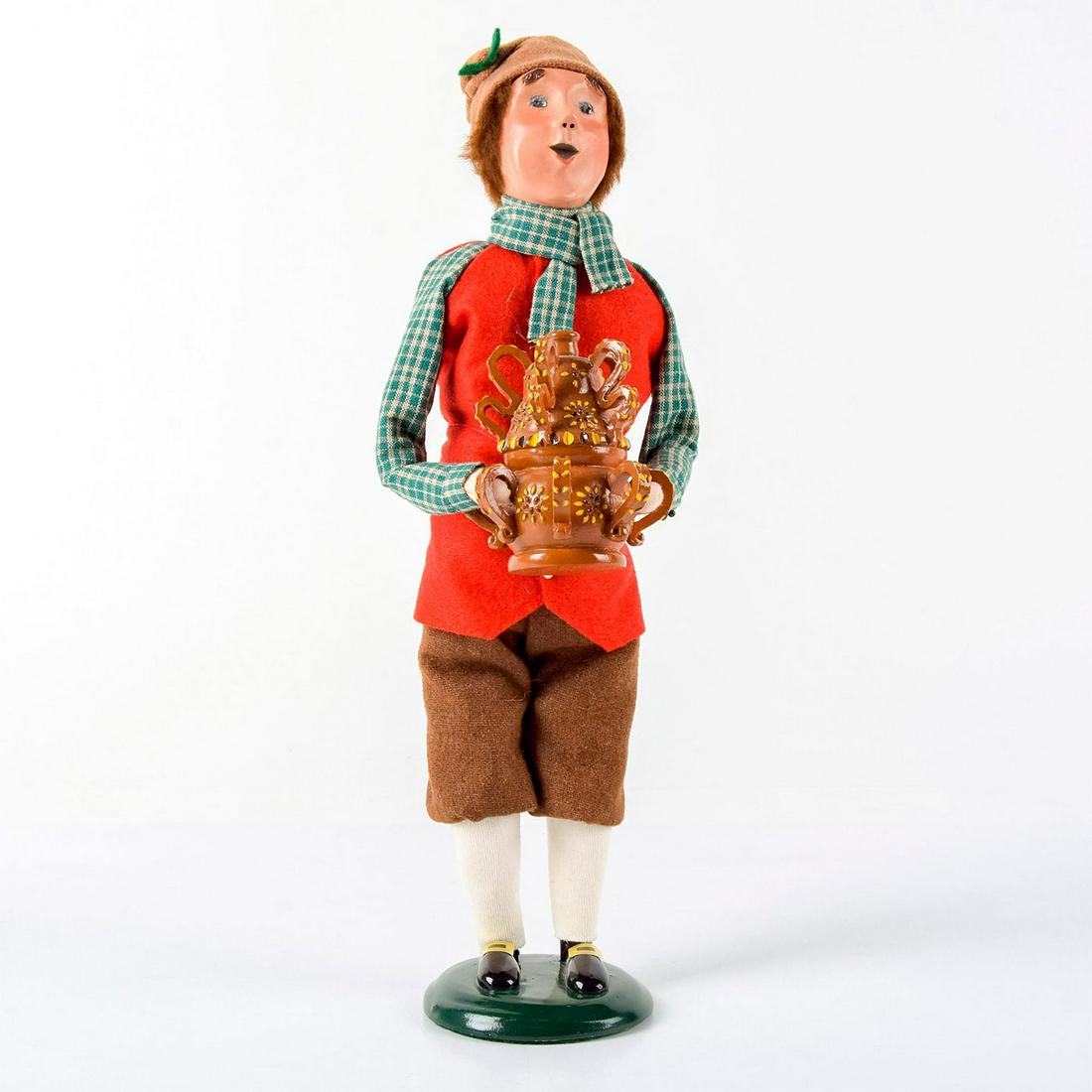 Byers Choice Figurine, The Carolers, Man with Wassail: Handcrafted figurine of a Wassail drink vendor. Red vest, green checkered shirt and brown pants. Handcrafted clay face and hand-made clothes. Byers Choice backstamp. Age related wares. Overall good co