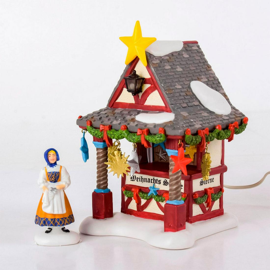 Set Of 2 Department 56 Figures, Christmas Market: Handpainted porcelain; comes with lighted tree topper booth figure and market woman figurine. The Heritage Village Collection, Alpine Village Series. With original box. Department 56 backstamps. Comes