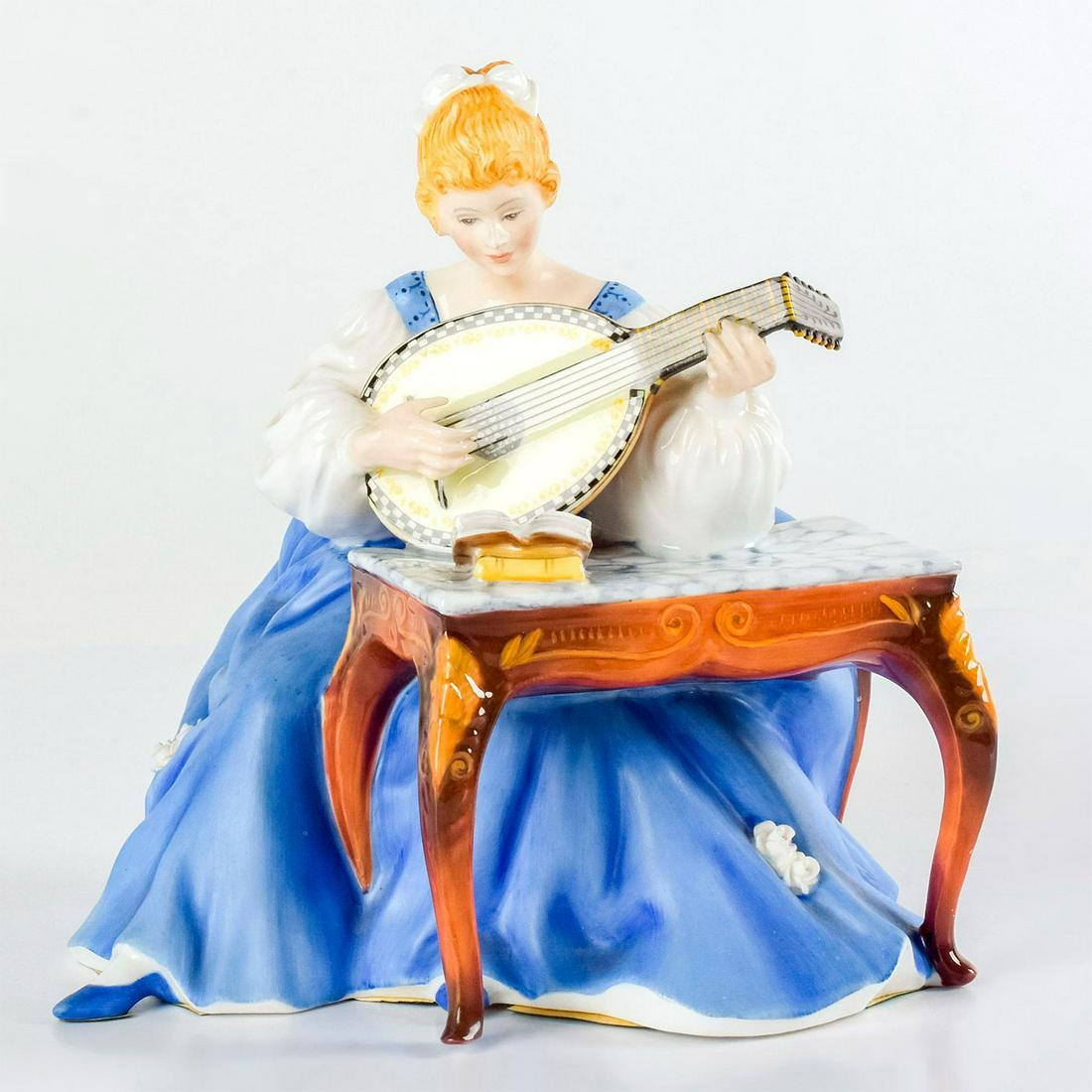 Lute HN2431 - Royal Doulton Figurine: She wears a blue and white 18th-century gown while playing the lute, with her sheet music on a table. The Lady Musicians series was characterized by its graceful and elegant reflection of the styles o