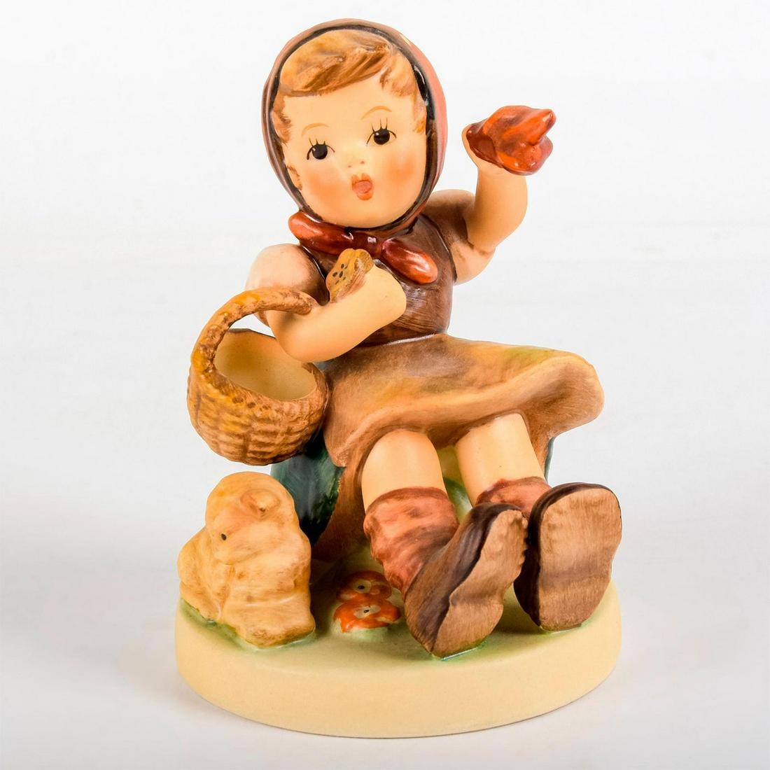 Farewell 65 - Goebel Hummel Figurine: Matte porcelain, hand painted. Young girl holding a basket and red handkerchief; seated next to lamb. 'M. I. Hummel' inscribed on base. Goebel backstamp. Age related crazing. Weight: 7.1 oz #g