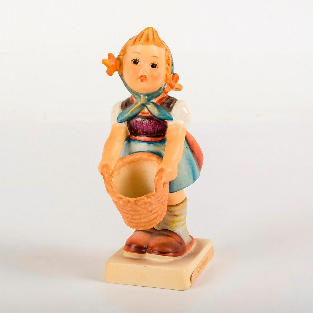 Little Helper 73 - Goebel Hummel Figurine: Matte porcelain, hand painted. Young girl in blue apron and bonnet holding a laundry basket. 'M. I. Hummel' inscribed on base. Goebel backstamp. Age related crazing. Weight: 2.5 oz #goebel #hu