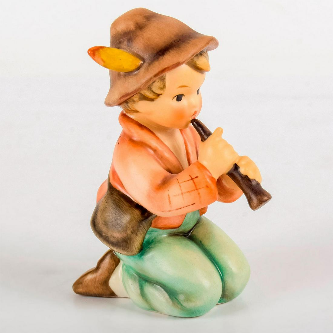Little Tooter 214H - Goebel Hummel Figurine: Matte porcelain, hand painted. Young boy in feathered hat playing a wind instrument. 'M. I. Hummel' inscribed on side. Goebel backstamp. Age related crazing. Weight: 3.1 oz #goebel #hummel #fi