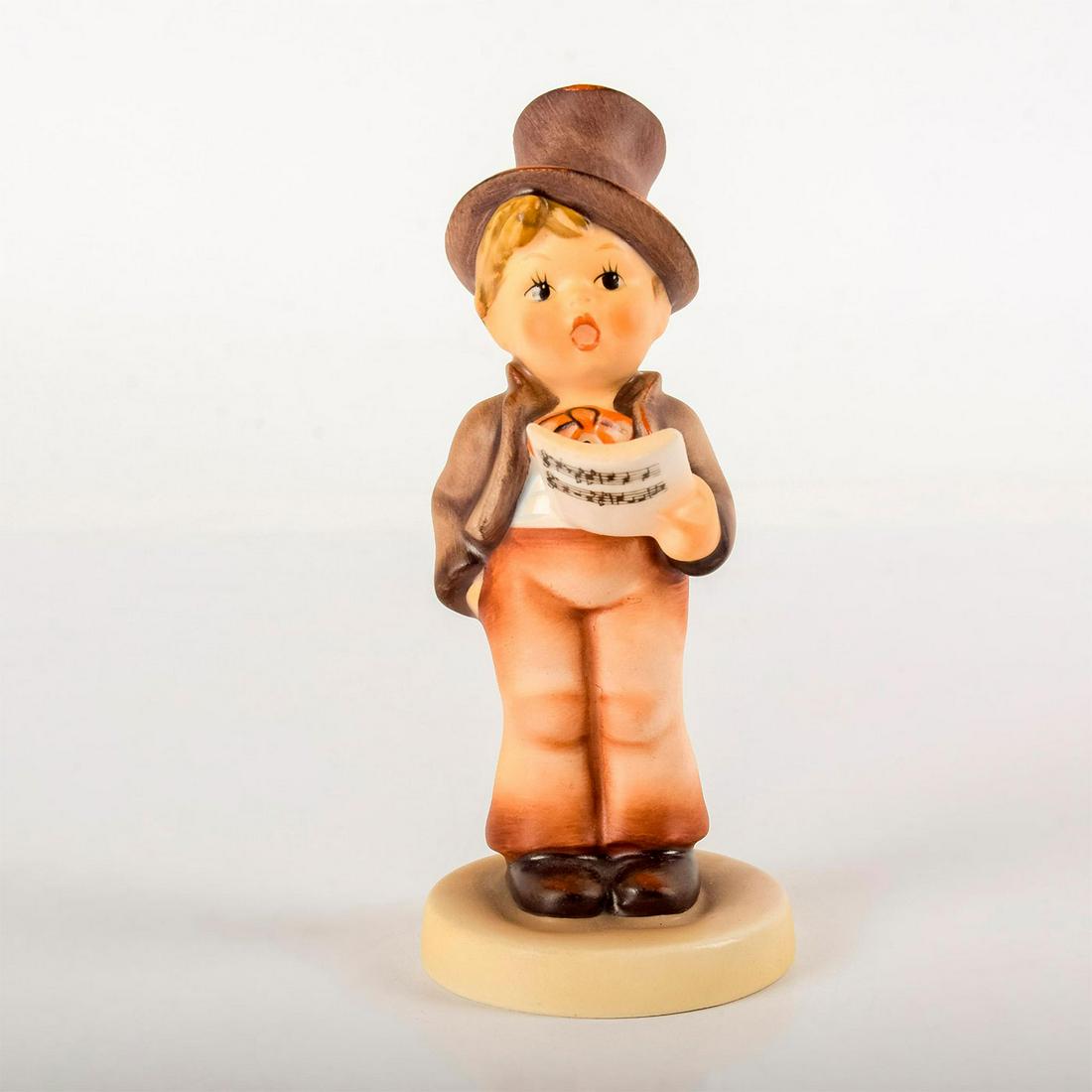 Street Singer 131 - Goebel Hummel Figurine: Matte porcelain, hand painted. Young boy in suit and top hat singing from a music sheet. 'M. I. Hummel' inscribed on base. Goebel backstamp. Minor chip on music sheet. Weight: 3.6 oz #goebel #