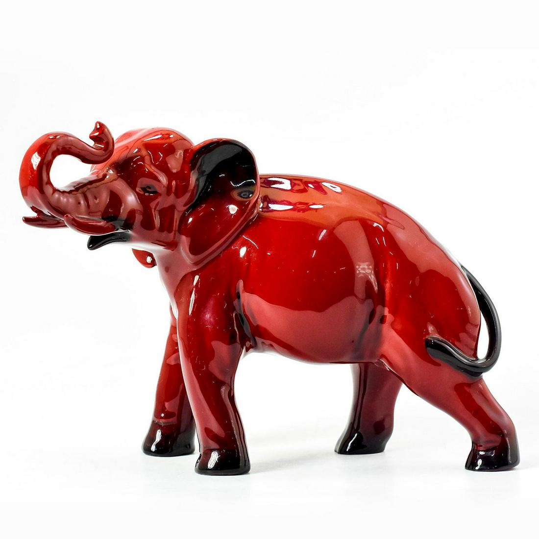 Royal Doulton Flambe Figurine Elephant, Trunk in Salute: Style one; medium size. Deep, rich red glaze; black accents. Standing position with raised trunk. Royal Doulton backstamp. Good condition. #elephant #flambe Artist: Charles Noke Issued: 20th c. Dimens