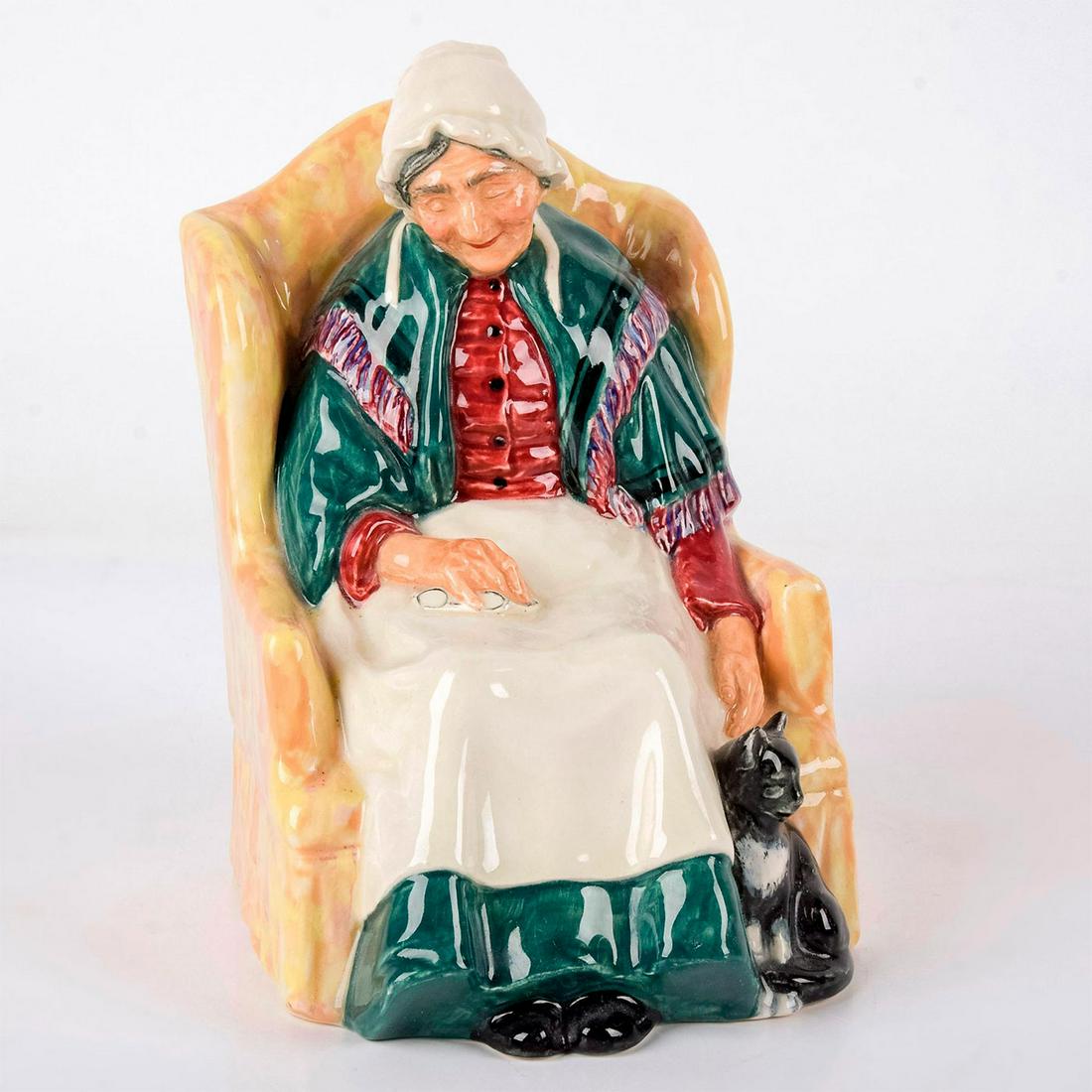 Forty Winks HN1974 - Royal Doulton Figurine: Woman sitting on a patterned chair, holding glasses, next to her cat. Series: Golden Years. Royal Doulton backstamp. Artist: Henry Fenton Issued: 1945 - 1973 Dimensions: 6.75"H Manufacturer: Royal Dou