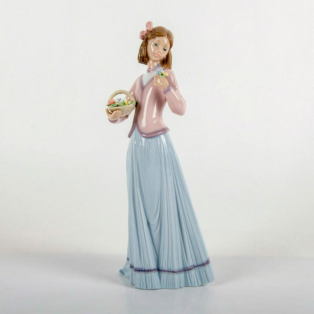 Lladro Porcelain Figurine, Innocence in Bloom 1007644: Gloss finish; modeled as a girl with a basket of beautiful flowers. Lladro Society Piece 1996 backstamp. Original box included. Weight: 1 lb 12.1 oz #lladro #porcelain Artist: Jose Puche Issued: 1996 