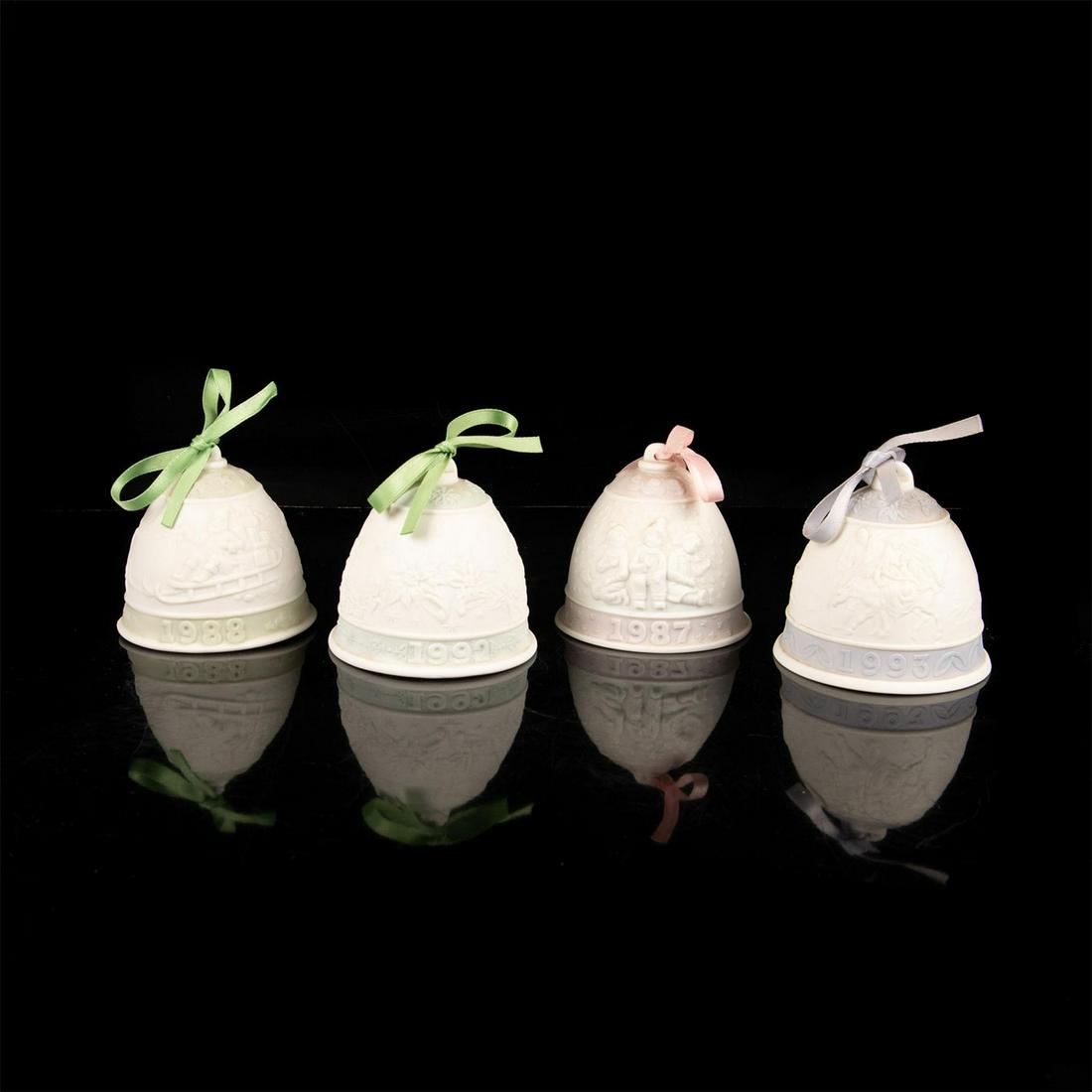 Set of 4 Lladro Porcelain Christmas Ornament Bells: 1987,1988,1992 and 1993 embossed Christmas bells for your tree. They are matte finish with light purple, pink and green colorations and ribbons. Scenes of children in the snow and on a sled and candle