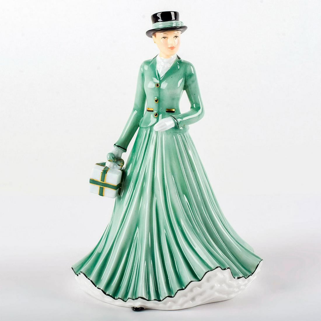 We Wish You A Merry Christmas HN5641 - From the Songs: Bone China. She wears a long green skirt and matching jacket with gold accents, carrying a gift. Series: Songs of Christmas. Royal Doulton backstamp. Artist: Neil Faulkner Issued: 2013 Dimensions: 6.7