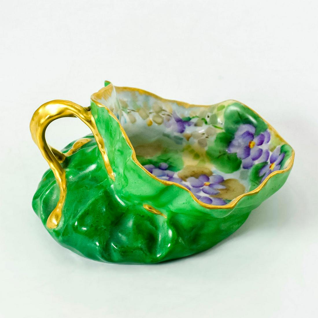 T & V Limoges Porcelain Trinket Tray, Violet Flowers: Stunning hand-painted gilt trinket tray in the shape of drawstring bag. Features violets flowers nestled in lush greenery. T & V Limoges backstamp. "Ruth" hand written on the bottom. Age related wear.