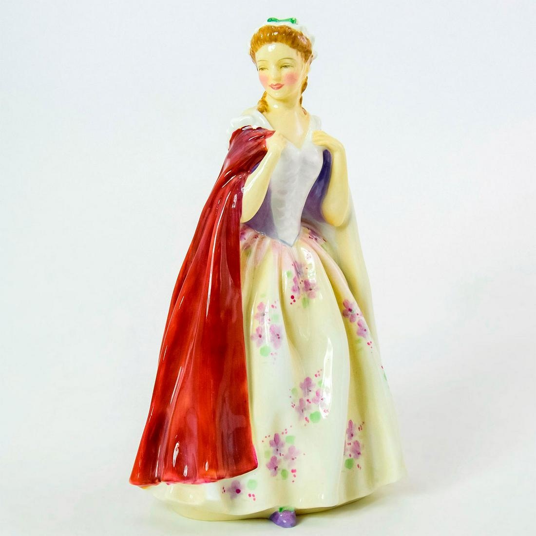 Bess HN2002 - Royal Doulton Figurine: Bone China. Lady wearing yellow dress with purple flowers and a red cape. Series: Harradine Classics. Royal Doulton backstamp. Weight: 11.4 oz Artist: Leslie Harradine Issued: 1947 - 1969 Dimensions: 