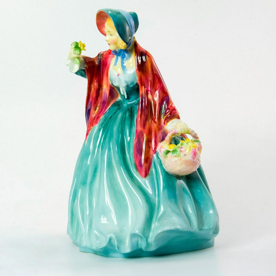 Lady Charmian HN1948 - Royal Doulton Figurine: Bone China. She wears a green dress with a red patterned shawl and holds a basket filled with delicate roses. Series: Harradine Classics. Royal Doulton backstamp. Artist: Leslie Harradine Issued: 1940
