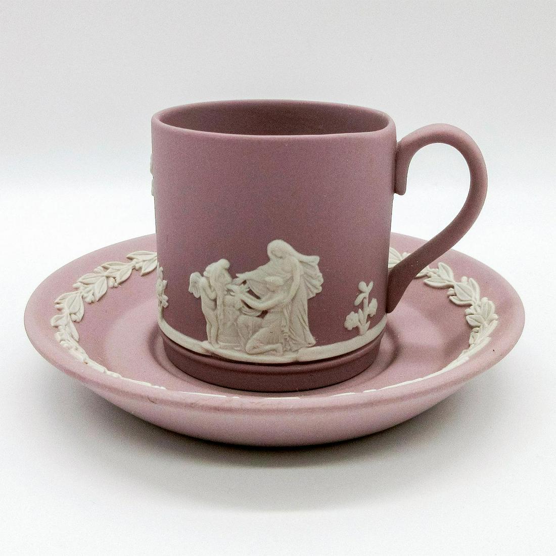 Wedgwood Lilac Jasperware Demitasse Cup and Saucer: Flat demitasse cup and saucer. Lilac colored ground with white relief Neoclassical designs; foliate border. Wedgwood impressed backstamp. Signed to base of saucer. #cupandsaucer Issued: 20th c. Dimens