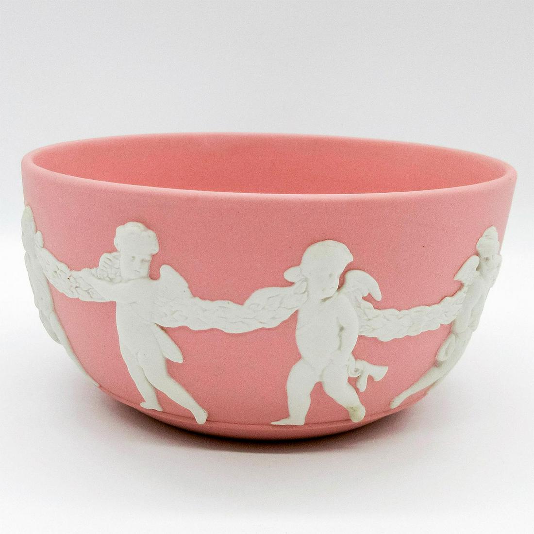 Wedgwood Pink Jasperware Bute Bowl, Cherubs: Matte pink colored ground with white relief design of cherubs encircling body. Wedgwood impressed backstamp. Minor discoloration. #bowl #cherubs Issued: 20th c. Dimensions: 5" dia Manufacturer: Wedgwo