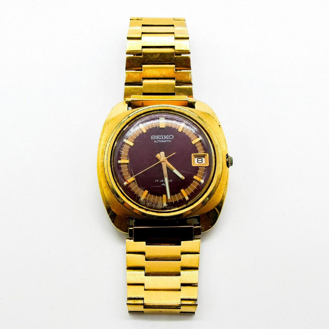 Vintage Seiko Automatic 7005-7089 Red Dial Watch: Base material; stainless steel. Original gold tone strap. 39mm case diameter, 10mm thick. Serial number 340159. 17 Jewels. Lug width 19mm. Water resistant. Date Indicator. Functional, movement accurac