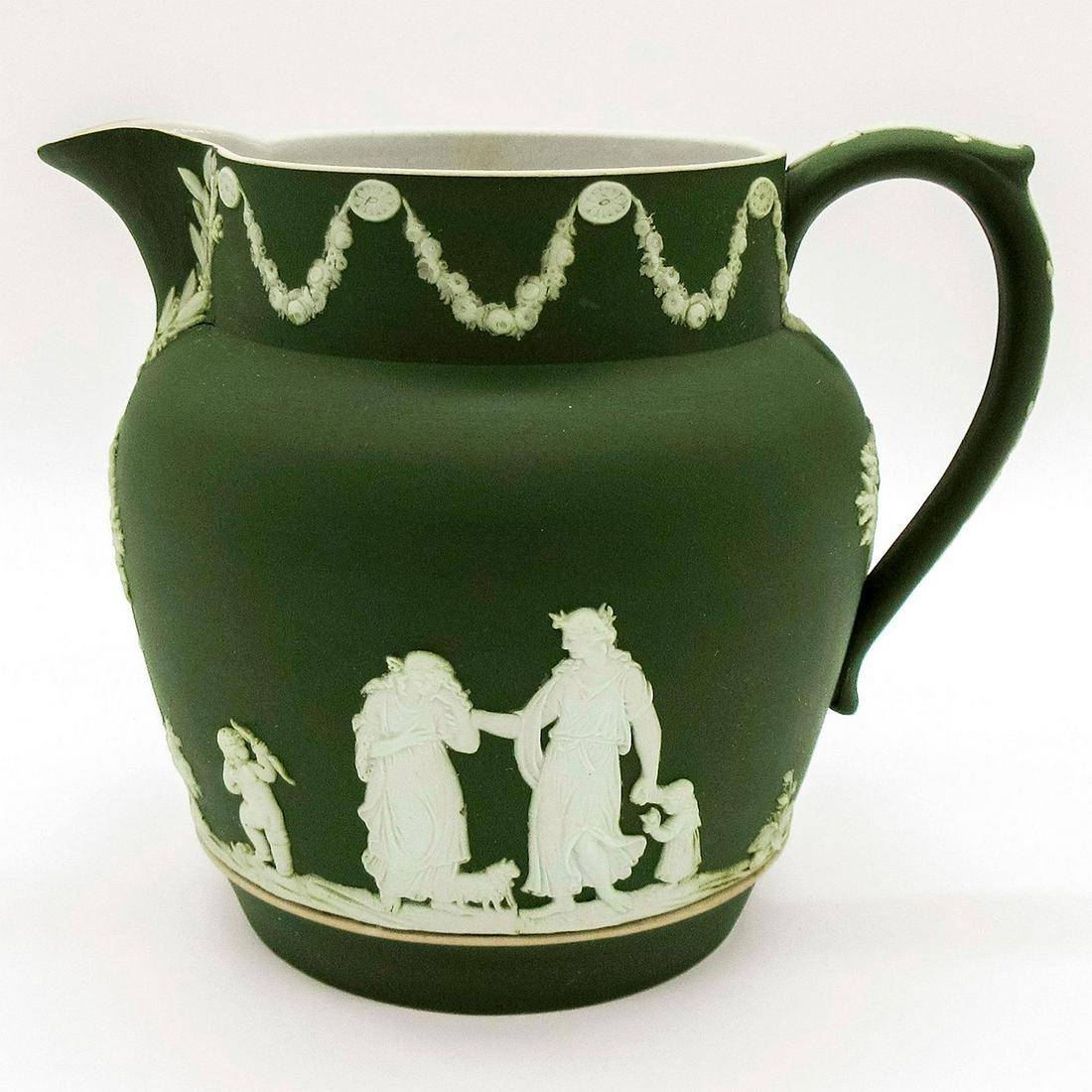 Wedgwood Olive Jasperware, Dutch Jug: Dutch jug dipped in olive green Jasperware with sprigged Neoclassical figures in white relief. Impressed Wedgwood backstamp. Minor age-related wear. #wedgwood #jasperware Issued: Early 20th c. Dimensi