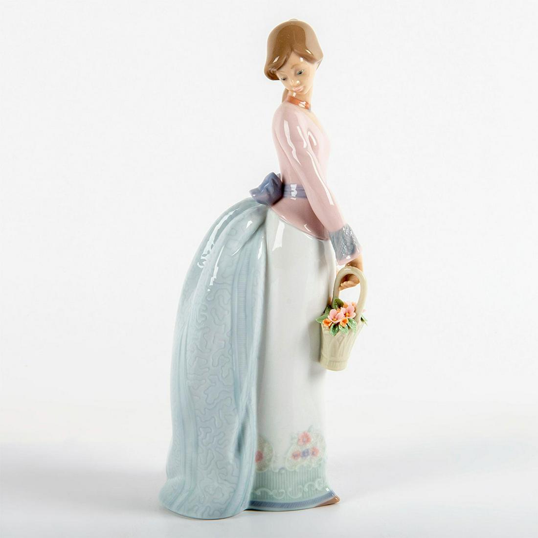 Basket of Love 1007622 - Lladro Porcelain Figurine: Glossy finish; Young lady holding a basket of flowers. Lladro backstamp. Original box included. Society Piece from 1994. Artist: Jose Puche Issued: 1994 - 1994 Dimensions: 9.75"H x 4"W Manufacturer: L