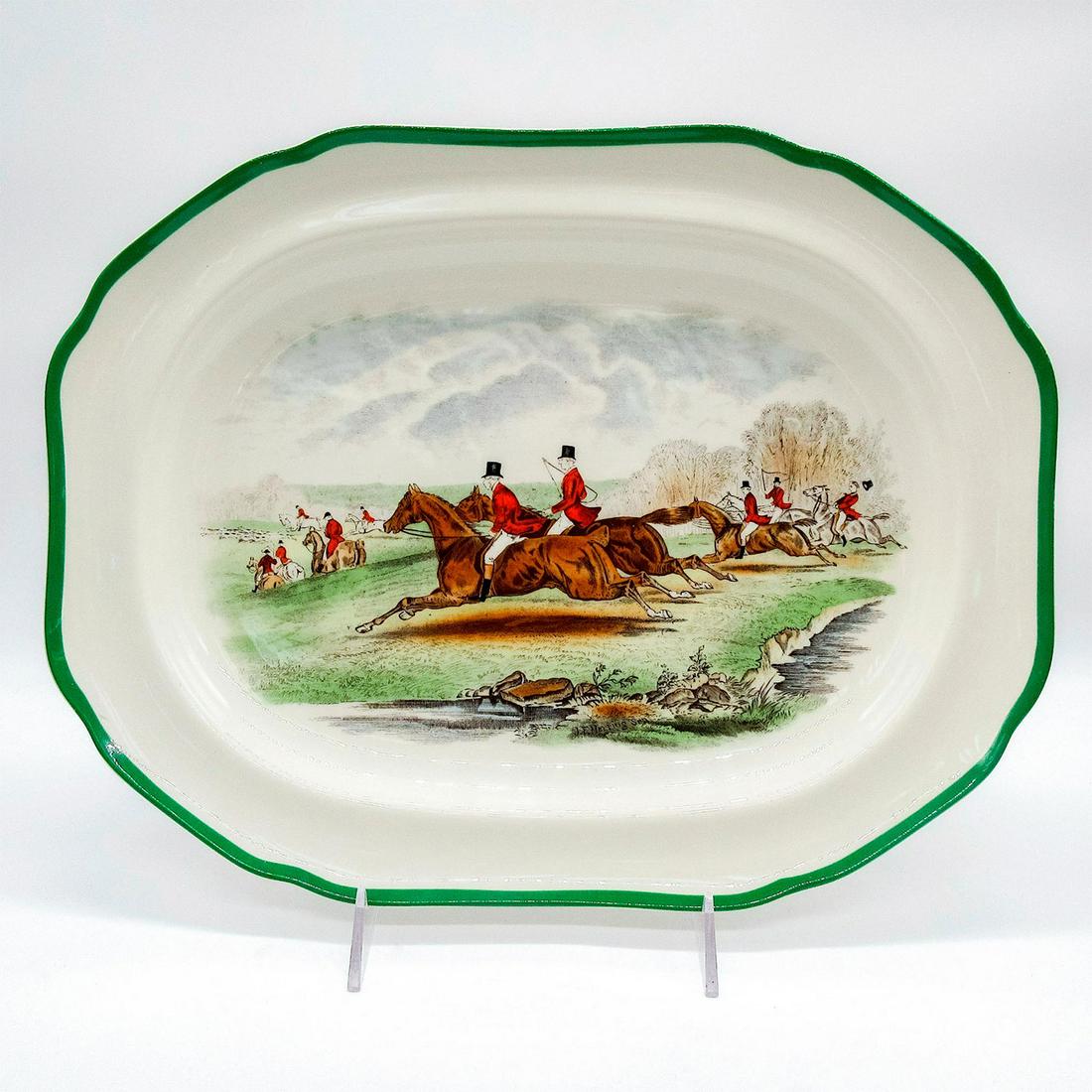 Spode The Hunt Porcelain Serving Platter: Oval off-white glazed serving platter with green rim and hunters scene in the center. Brown, green and gray colorations. The Find scene displays men in red jackets on horses running. Spode backstamp. 