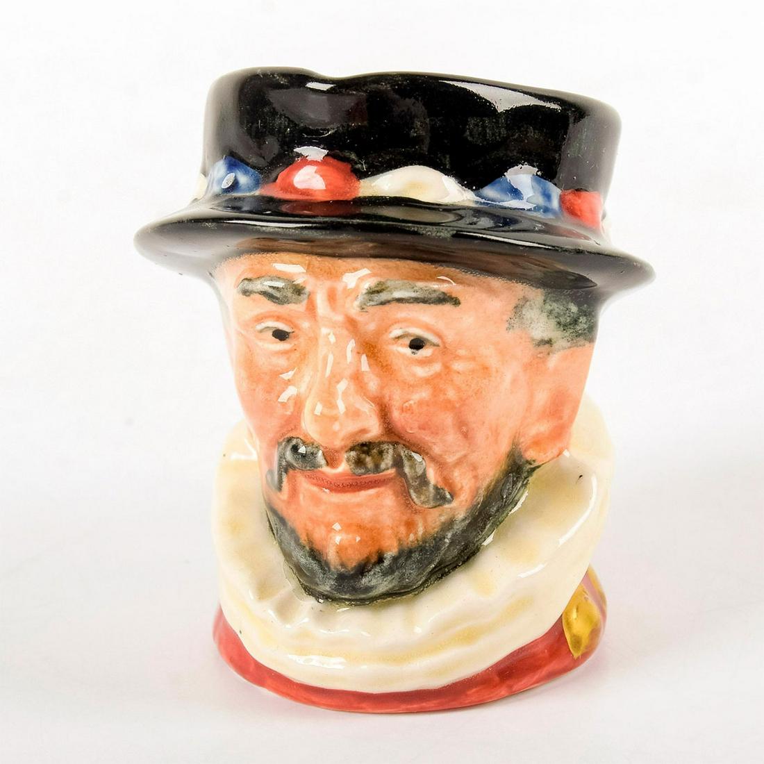 Royal Doulton Mini Character Jug, Beefeater GR Gold Gilt - Mini - Royal Doulton Character Jug: D6251, variation two, gold gilt highlight "GR" cypher on handle. Pink, white, black and blue coloration. Royal Doulton backstamp. Good condition. #Beefeater Artist: Harry Fenton Issued: 1947 D