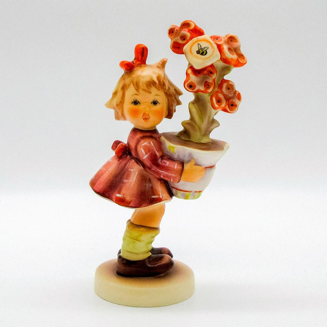 Best Wishes 540 - Goebel Hummel Figurine: First issue 1997 special event hand painted girl with flower pot. Girl with red dress, yellow socks and red hair bow presents tall flowers marked with a bee. Goebel backstamp. #goebel #hummel #bestwis