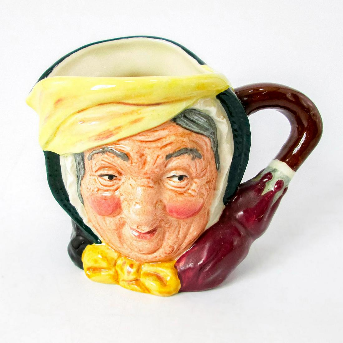 Sairey Gamp D6789 (Colorway) - Small - Royal Doulton Character Jug: Yellow band on hat; yellow bow; issued 1987 in limited edition of 500. Artist: Leslie Harradine and Harry Fenton Issued: 1935-1986 Dimensions: 3"H Manufacturer: Royal Doulton Country of Origin: Englan