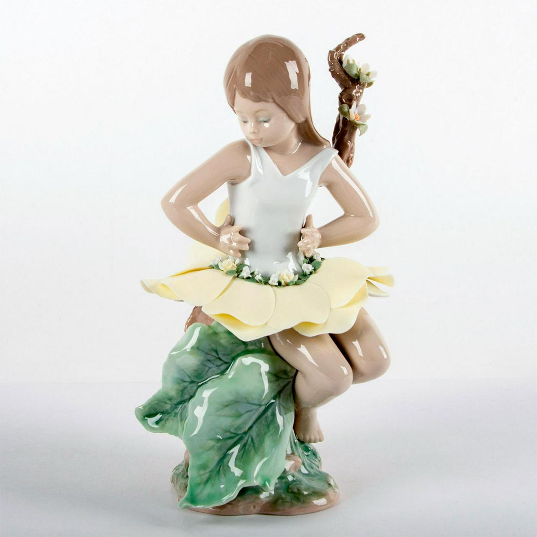 In A Magical Garden 1006877 - Lladro Porcelain Figurine: Glossy finish; Girl in a dainty flower petal skirt sits for a rest at the base of a tree. Lladro backstamp. Original box included. Artist: Francisco Polope Issued: 2002 - 2004 Dimensions: 10"H Manufac