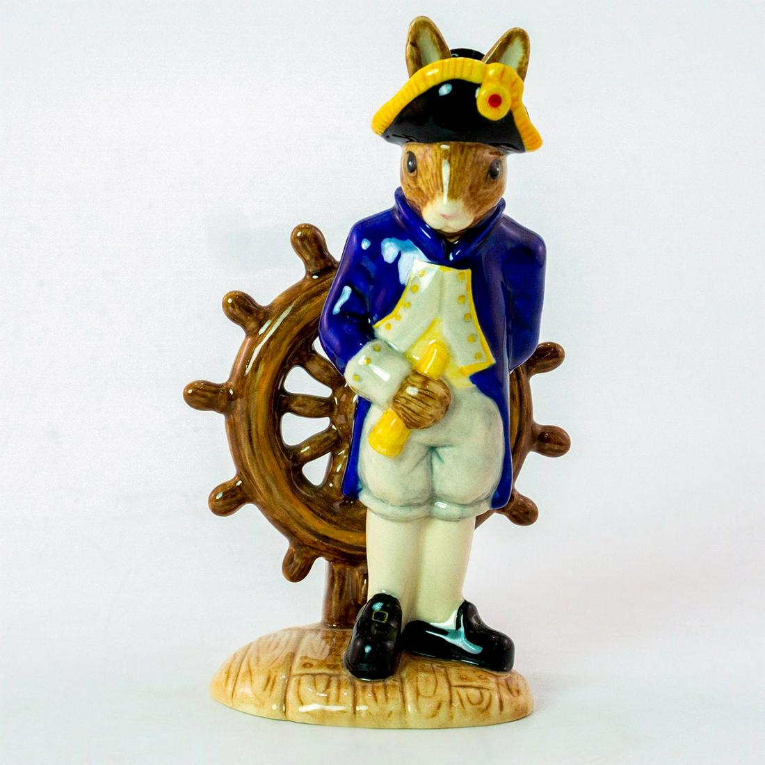 Boatswain Bunnykins DB323 - Royal Doulton Bunnykins: Bunny in dark blue, white and yellow boats uniform holding a telescope next to a helm. The Shipmates Collection. With certificate. Royal Doulton backstamp. Weight: 3.9oz Artist: C. Dadd Issued: 2004 D