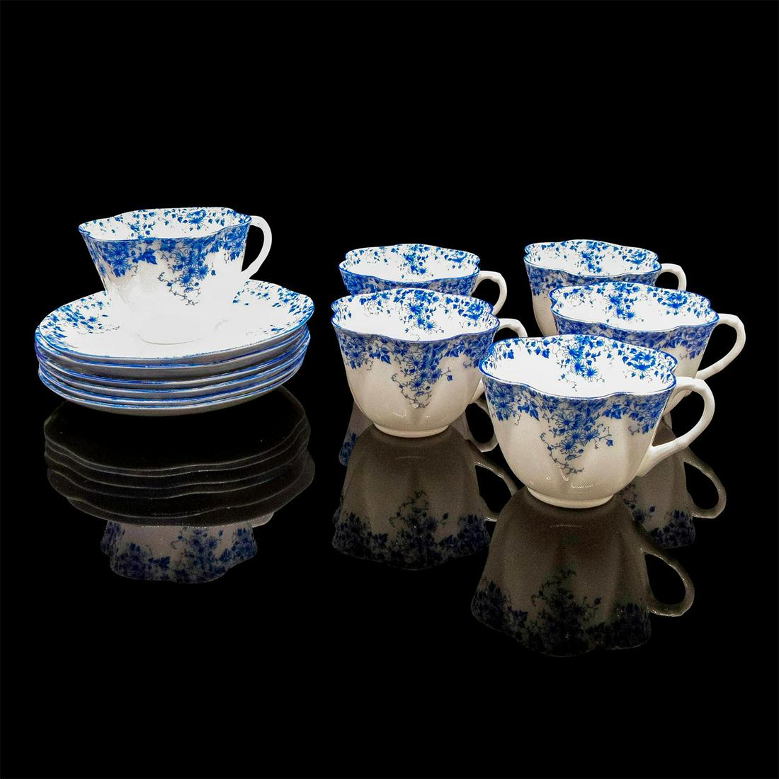 12pc Shelley England Tea Cup and Saucer, Dainty Blue: Fine Bone China decorated with daisies on a vine in blue over white. Scalloped rims. Fine Bone China Shelley England backstamp. Some marked with "Dainty Blue." 6 Tea Cups each: 2.25"H and