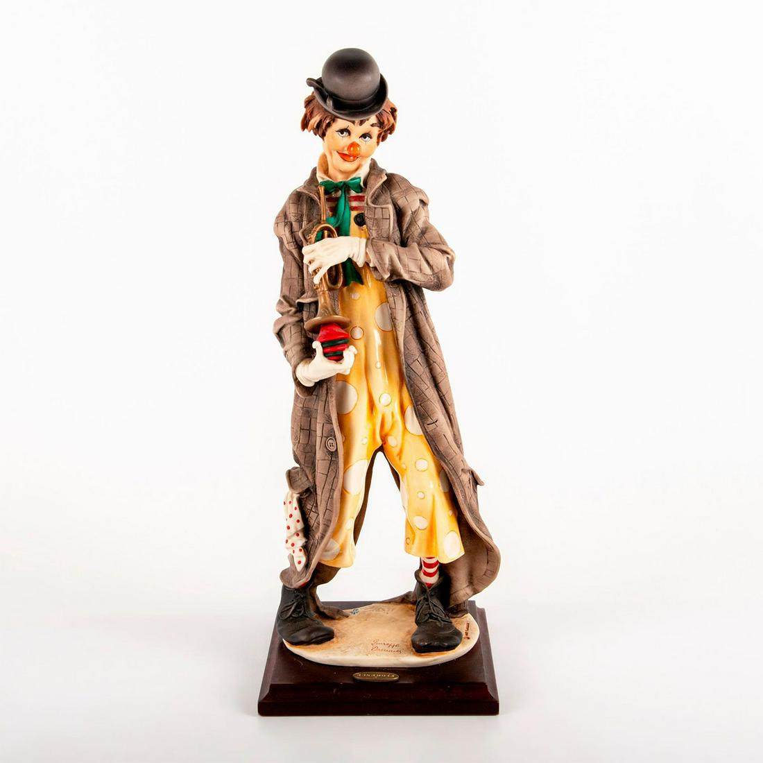 Florence Giuseppe Armani Figurine, The Musical Clown: Modelled as a clown holding a trumpet. Matte; brown, orange and green coloration. Signed Giuseppe Armani. Mounted on wooden base. Weight: 7.5 lbs #clown Issued: 20th c. Dimensions: 17.75"H Manufacture